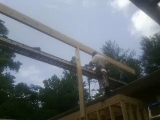 Carpenter setting a ridge beam over a new addition frame — Ice Dam Removal by Roofing Brothers in Zarephath