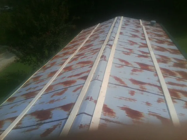 Rusted metal roof panels with new wood purlins before replacement — Storm Damage Roof Repair in Zarephath by Roofing Brothers