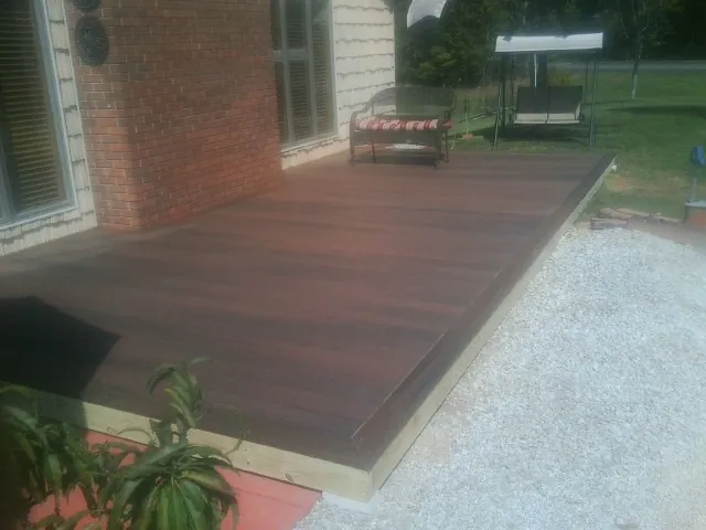 Freshly stained wood deck built against a brick home in Zarephath